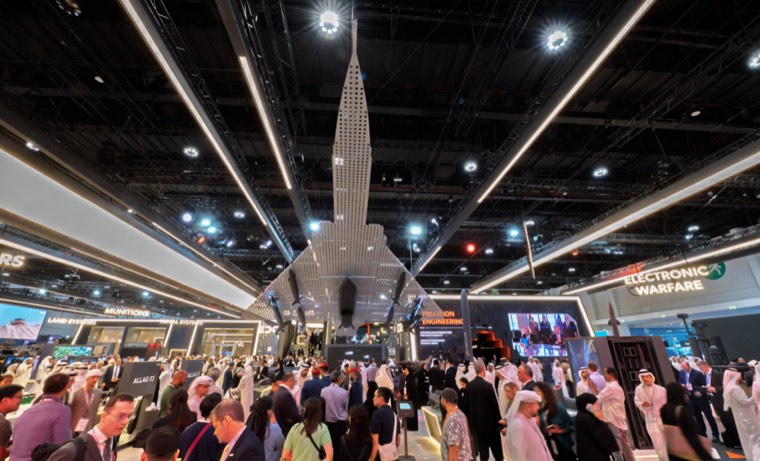Visitors filling a large IDEX hall beneath a suspended aircraft display