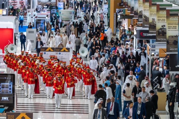 A ceremonial band moving through a crowded IDEX concourse