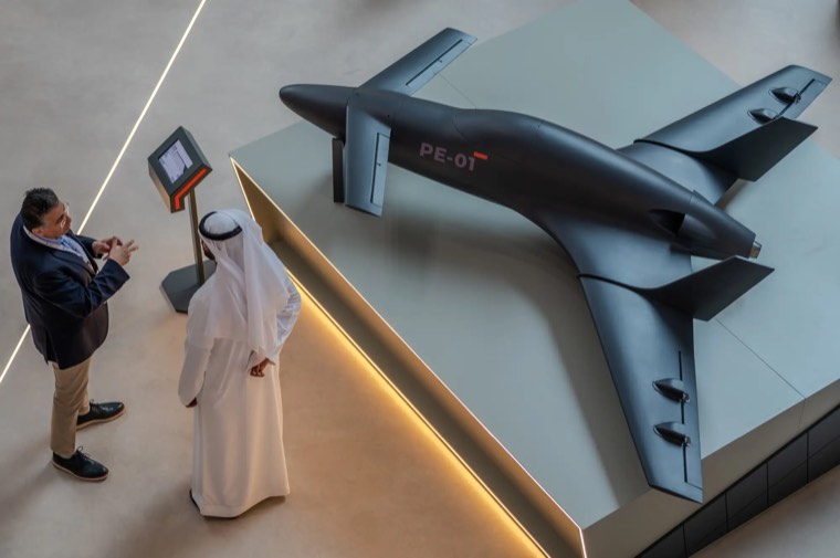 Two visitors discussing a concept aircraft model at a stand