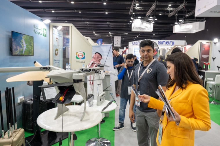 Visitors inspecting an unmanned aircraft system at an exhibition stand