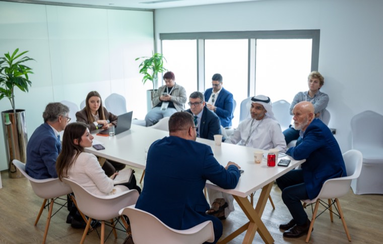 Delegates holding a formal meeting around a table at IDEX