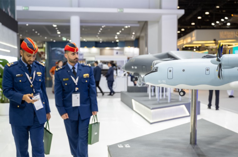 Uniformed officers inspecting aircraft models at an exhibition stand