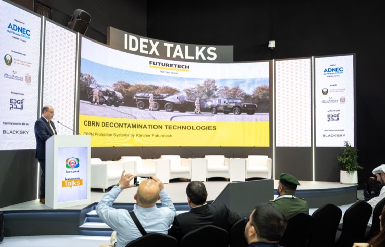 A speaker addressing an audience during IDEX Talks